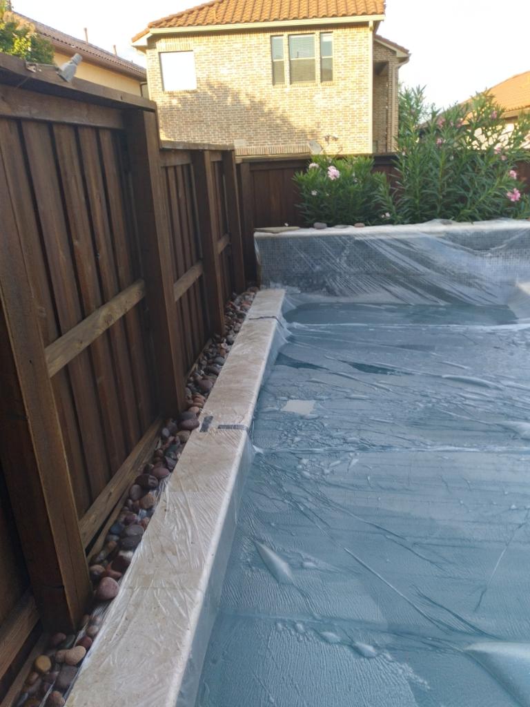 Picture a stained fence with a covered pool